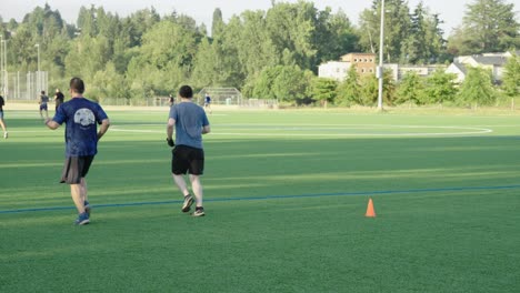 Reife-Männer,-Die-Auf-Einem-Fußballfeld-Laufen-Und-Joggen