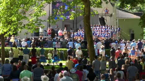 Coro-De-Niños-En-Un-Concierto-Al-Aire-Libre-Con-Una-Gran-Multitud-De-Personas