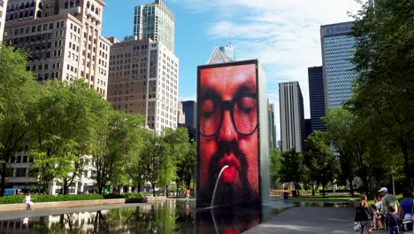 People-Enjoying-A-Day-At-A-City-Park-Fountain-In-Summer-Morning-With-Skyline