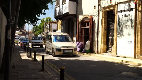 Cars-driving-near-shops-and-restaurants-in-Girne-street-near-the-famous-Ledra-crossing-in-in-the-old-city-of-Nicosia