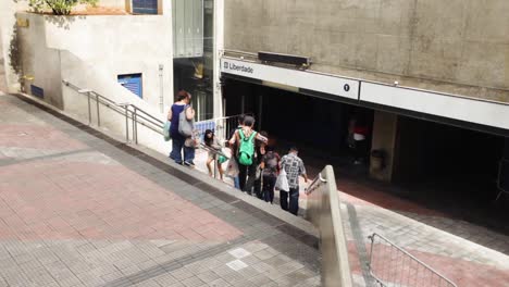 Gente-Yendo-Y-Viniendo-A-La-Entrada-Y-Salida-De-La-Estación-De-Metro-En-El-Barrio-Japonés-De-Liberdade-En-São-Paulo,-Brasil