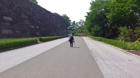 POV-walking,-A-view-from-Royal-Palace-garden-to-city-with-people-walking