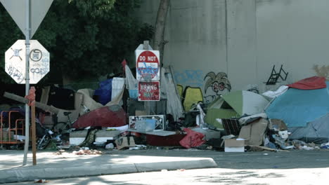 Toma-Amplia-Mientras-La-Cámara-Recorre-Un-Campamento-De-Personas-Sin-Hogar-Cerca-De-Un-Paso-Elevado-De-La-Autopista