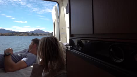 Junges-Paar-Liegt-Hinten-Im-Wohnmobil-Und-Blickt-Auf-Den-Lake-Wanaka,-Neuseeland