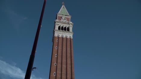 Primer-Plano-Del-Campanario-De-San-Marcos,-Fondo-De-Cielo-Azul-Y-Pájaros-Volando-En-Venecia,-Italia