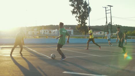 Group-of-Refugee-Boys-and-Men-Playing-Football-on-a-Blacktop-Court