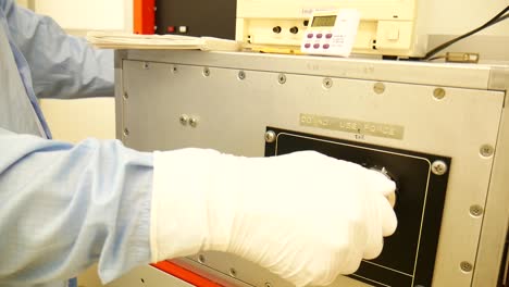 A-scientist-handling-a-big-centrifuge,-reading-the-data-of-a-big-computer