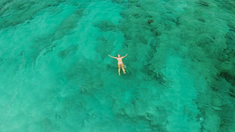 Chica-Nadando-Y-Flotando-En-Una-Increíble-Agua-De-Océano-Teñida-De-Verde-Claro-Durante-Unas-Vacaciones