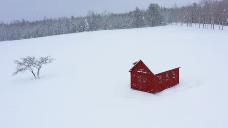 Umlaufen-Um-Eine-Rote-Scheune-Und-Einen-Apfelbaum-In-Einem-Verschneiten-Feld-Während-Eines-Schneesturms-In-Zeitlupe