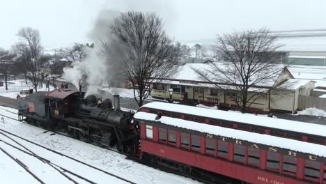 Conductor-Aéreo-Se-Encuentra-Junto-A-La-Máquina-De-Vapor-Restaurada-Strasburg-Ronks-Del-Ferrocarril,-Concepto-De-Pennsylvania:-Transporte,-Ferrocarriles,-Americana,-Nostalgia,-Tradicional,-Invierno,-Expreso-Polar