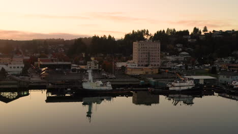 Wharf-and-boats-in-Coos-Bay-at-dusk,-drone-flies-backwards