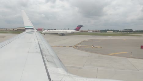 Mirando-Por-La-Ventana-De-Un-Avión-Rodando-En-El-Metro-Dtw-Detroit,-Con-Vistas-Al-Ala,-Nublado