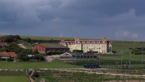 Estrecha-Vista-De-Perfil-Aéreo-De-La-Escuela-Roedean,-Situada-En-Los-Acantilados-De-Tiza-Cerca-De-Brighton,-Reino-Unido