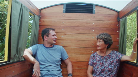 Close-up-of-mother-and-son-talking-on-small-old-fashioned-train