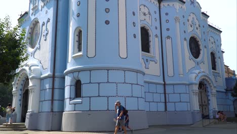 Vista-Frontal-De-La-Iglesia-Azul-Mientras-La-Gente-Camina,-Todavía-Tiro