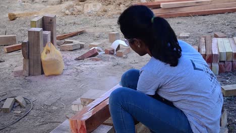 Una-Niña-Cortando-Un-Bloque-De-Madera-En-Un-Taller-Realizado-Durante-Un-Festival-Universitario-De-Arquitectura-En-Kerala