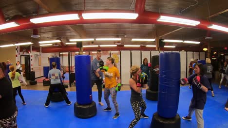 Adult-students-practicing-backhand-strikes-and-punches-while-participating-in-a-self-defense-class-at-martial-arts-school