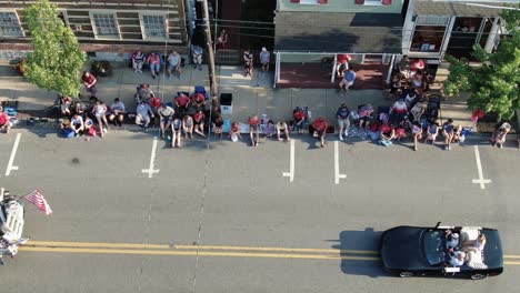 US-Navy-Veterans-in-ship-float-wave-to-parade-observers,-homecoming-court-girl-waving-to-crowds