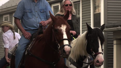 Man,-woman,-and-girl-riding-horses-in-parade,-Slow-Motion