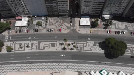 Von-Oben-Nach-Unten-Schwenkender-Blick-Auf-Den-Copacabana-Strand,-Die-Boulevardstraße-Und-Den-Bürgersteig-An-Einem-Strahlend-Sonnigen-Sommertag-Mit-Wenig-Verkehr-Während-Des-Ausbruchs-Des-Covid-19-Coronavirus