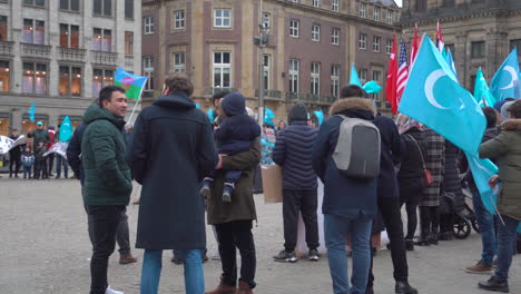 Panning-shot-of-a-East-Turkestan-demonstration-against-the-Chinese-cultural-genocide-of-Uyghurs,-in-the-middle-of-Dam-Square-in-Amsterdam