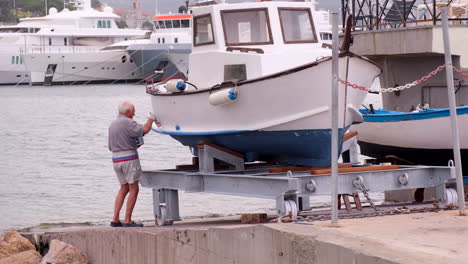 Old-man-painting-a-boat