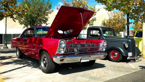 Red-1960s-Ford-Fairlane-on-display-with-hood-open,-pan,-slow-motion