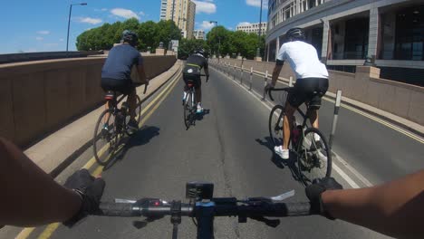 POV-Von-Radfahrern,-Die-Mit-Einem-Vorbeifahrenden-Bus-Die-Westferry-Road-In-Canary-Wharf-Hinauffahren