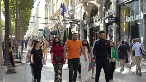 Tourists-and-visitors-wearing-or-not-face-masks-against-coronavirus-walking-on-the-Champs-Elysee-sidewalk-without-respecting-sanitary-distances