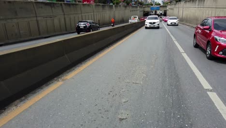 Cars-and-Vehicles-coming-out-of-an-underpass-in-Bangkok,-along-Ratchada-road,Thailand