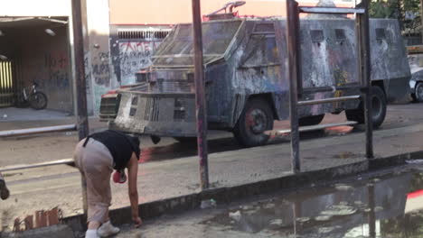 Los-Alborotadores-Persiguen-Y-Arrojan-Piedras-Al-Vehículo-De-La-Policía-Antidisturbios,-La-Policía-Antidisturbios-Dispersa-A-La-Multitud-Con-Una-Manguera-Contra-Incendios