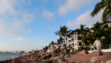 A-person-walking-on-a-sidewalk-during-sunset-in-Puerto-Vallarta,-Mexico