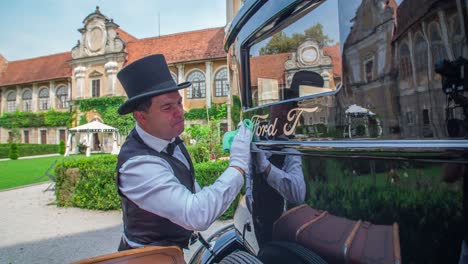 Hombre-Con-Sombrero-De-Copa-Y-Chaleco-Formal-Limpia-Una-Ventana-De-Coche-Ford-Modelo-T-Vintage