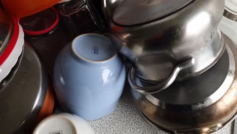 pile-of-washed-Dishes-On-A-Sink-Drainer