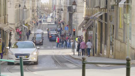 A-view-of-the-Lisbon-tram-moving-on-its-track-where-as-lots-of-tourists-visiting-the-old-city-of-Portugal