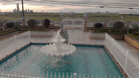 Aerial-4K-Footage-front-elephant-sculpture-in-front-of-Sikh-temple-with-beautiful-and-elaborate-sculpture-and-symmetrical-architecture-and-water-fountain