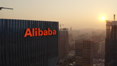 Naher-Vorbeiflug-In-Der-Nähe-Des-Bürogebäudes-Der-Alibaba-Gruppe-Mit-Der-Enthüllung-Des-Canton-Tower-Und-Des-CBD-Bereichs-Im-Stadtzentrum-Im-Hintergrund-Bei-Wunderschönem-Goldenen-Sonnenuntergang