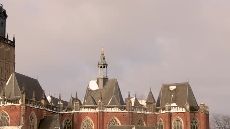 Panorámica-Lenta-Y-Revelación-De-La-Torre-De-La-Catedral-De-Walburgiskerk-En-El-Paisaje-Nevado-De-Invierno-Al-Atardecer