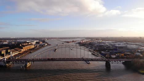 Luftdrohnenaufnahme-Von-Brug-Over-De-Noord-Mit-Verkehr-Und-Lastkähnen,-Die-Sich-Am-Sonnigen-Nachmittag-Nähern