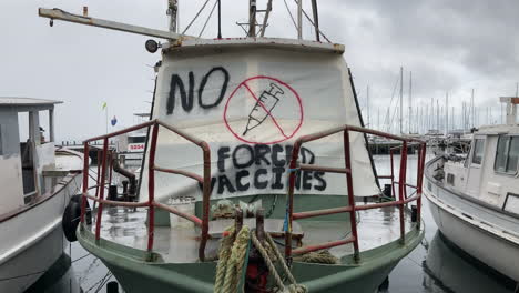 Ein-Schild-Mit-Der-Aufschrift-„Keine-Zwangsimpfungen“-Hängt-über-Einem-Angedockten-Boot