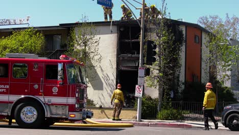 Bomberos-Cortando-Un-Techo,-Tratando-De-Entrar-En-Un-Edificio-Quemado-En-Los-Ángeles,-EE.UU.