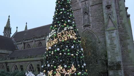 Niño-Feliz-Sentado-Posando-Bajo-La-Iluminación-Del-árbol-De-Navidad-De-La-Iglesia-De-La-Plaza-De-Toros-De-Birmingham