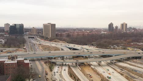 Una-Vista-Aérea-De-Una-Intersección-De-Carreteras-Con-Tráfico-Urbano-Fluido-En-Una-Tarde-Nublada-De-Domingo-En-Invierno