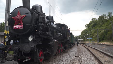 Steam-train-conductor-peeking-from-cabin-before-departure-from-station