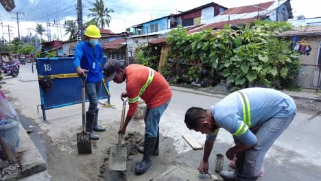 Los-Capataces-Que-Vestían-Chalecos-Reflectantes-De-Seguridad-Utilizaron-Su-Pala,-Mezcla-De-Cemento-Y-Un-Martillo-De-Demolición-Para-Realizar-Una-Excavación-Junto-A-La-Cuneta-Del-Camino-Para-Instalar-Nuevas-Tuberías-De-Agua-Desde-La-Línea-De-Agua-Principal.