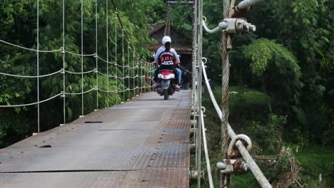 Puente-Colgante-Sobre-El-Río-Con-Cruce-De-Motocicletas-Por-La-Mañana-En-Sukabumi,-Java-Occidental,-Indonesia-El-4-De-Mayo-De-2022