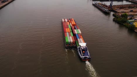 Vista-Aérea-Sobre-El-Puente-Sobre-El-Norte-De-Maas-Barcaza-De-Remolque-Que-Transporta-Contenedores-De-Carga-A-Lo-Largo-Del-Río-Que-Pasa