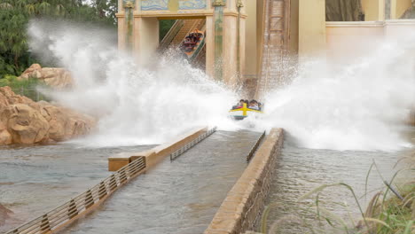 Slow-Motion-Static-Shot-of-the-Journey-to-Atlantis-Log-Flume-Ride-Going-Down-a-Drop-and-Splashing-in-the-Water-at-SeaWorld-in-Orlando