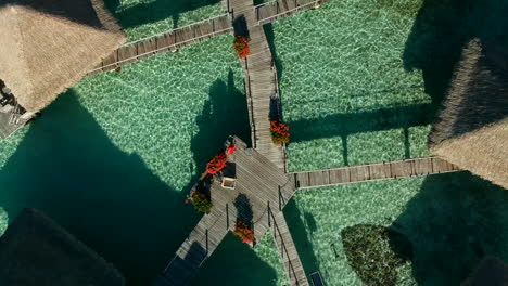 Dolly-upwards-in-birdseye-view-of-overwater-bungalows-in-Bora-Bora,-French-Polynesia