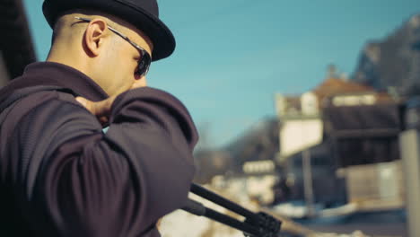 Photographer-walks-into-idyllic-mountain-town-in-the-alps-in-slow-Mo